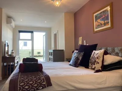 a bedroom with a large bed and a window at The Quies in Newquay