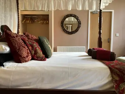 a large bed with red and green pillows on it at The Quies in Newquay