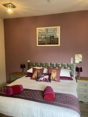 a bedroom with a large bed with pillows on it at The Quies in Newquay