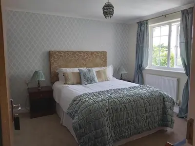a bedroom with a large bed and a window at Porth Lodge in Newquay