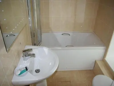 a bathroom with a sink and a bath tub at Porth Lodge in Newquay