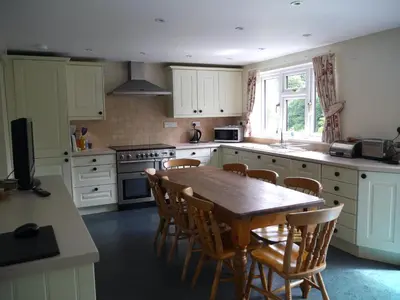 a kitchen with a wooden table and chairs in it at Cosy holiday cottage in Boscastle in Boscastle