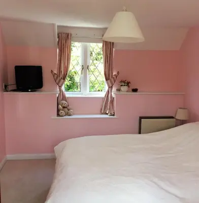 a bedroom with a white bed and a window at Cosy holiday cottage in Boscastle in Boscastle