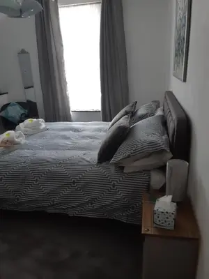 a bedroom with a bed with pillows and a window at Tregella Guest House in Newquay