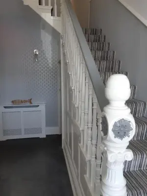 a white staircase with a white spiral stair case at Tregella Guest House in Newquay