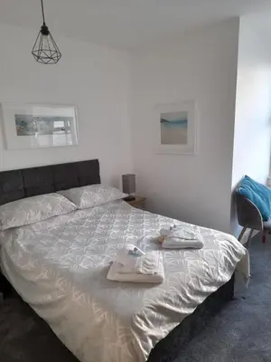 a bedroom with a bed with two towels on it at Tregella Guest House in Newquay