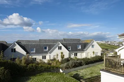 a large white house with black roof at 4 Glendorgal Sands, Newquay in Newquay