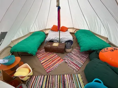 a white tent with a bed and mats in it at Luxury Glamping - Heydaze in Lostwithiel