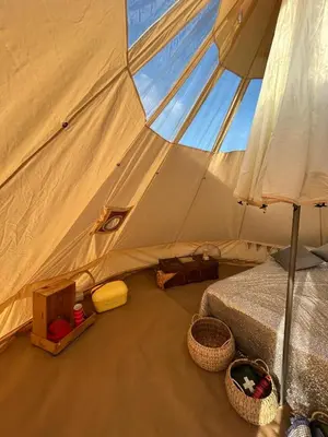 a tent with a bed and baskets in it at Luxury Glamping - Heydaze in Lostwithiel