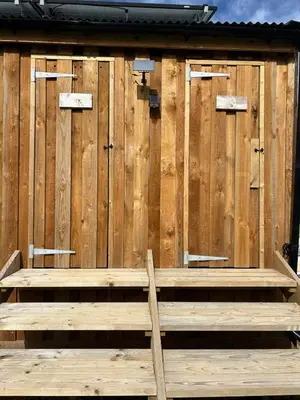 a wooden building with a bench in front of it at Luxury Glamping - Heydaze in Lostwithiel