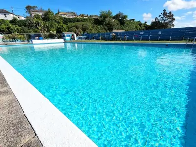 a large swimming pool with blue water at Luxury Waterfront 3 Bedroom/3 Bathroom Townhouse in Hayle