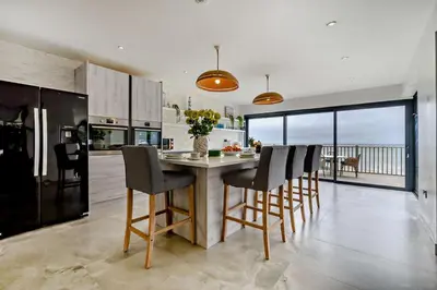 a kitchen with a table and chairs and a kitchen with a view at 3 Bed in Downderry oc-s29364 in Downderry