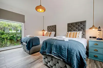 a bedroom with two beds and a window at 3 Bed in Downderry oc-s29364 in Downderry