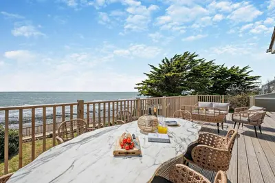 a table on a deck with a view of the ocean at 3 Bed in Downderry oc-s29364 in Downderry
