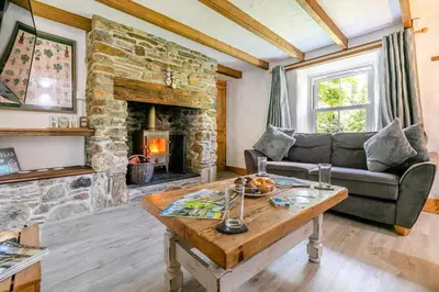 a living room with a couch and a stone fireplace at 3 Bed in Cambrose oc-h29392 in Camborne