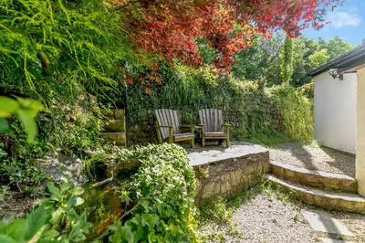 two chairs sitting on a stone bench in a garden at 3 Bed in Cambrose oc-h29392 in Camborne