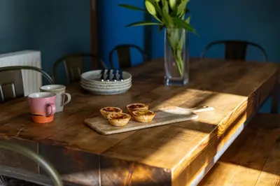 a wooden table with three cupcakes on a tray at 3 Bed in Mawgan Porth oc-s29403 in Mawgan Porth
