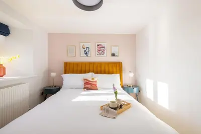 a bedroom with a white bed with a wooden headboard at 3 Bed in Mawgan Porth oc-s29403 in Mawgan Porth