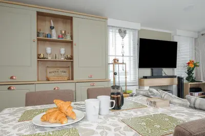a dining room table with a plate of croissants on it at Polperro Road in Looe