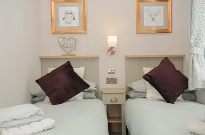 two beds in a room with towels on them at Polperro Road in Looe