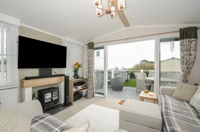 a living room with a television and a fireplace at Polperro Road in Looe