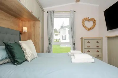 a bedroom with a large bed with a large window at Polperro Road in Looe