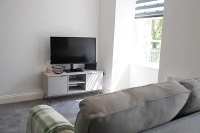a living room with a couch and a flat screen tv at No.9 Priory House, Bodmin in Bodmin