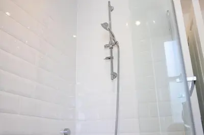 a shower in a bathroom with white tile at No.9 Priory House, Bodmin in Bodmin
