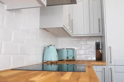 a kitchen with white cabinets and a blue appliance at No.9 Priory House, Bodmin in Bodmin