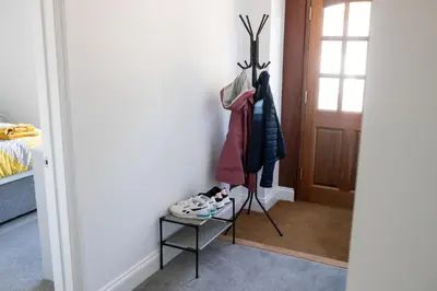 a hallway with a door and a rack of clothes at No.9 Priory House, Bodmin in Bodmin