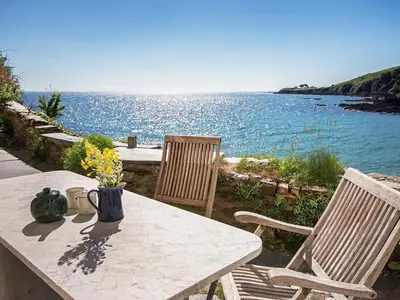 a table and chairs with a view of the water at Mermaid Cottage - Uk47403 in Portmellon