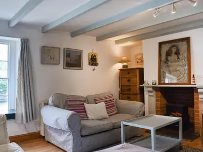 a living room with a couch and a fireplace at Mermaid Cottage - Uk47403 in Portmellon