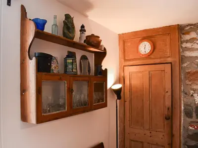 a room with a clock on the wall and a door at Mermaid Cottage - Uk47403 in Portmellon