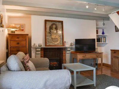 a living room with a couch and a fireplace at Mermaid Cottage - Uk47403 in Portmellon