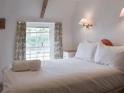 a bedroom with a large white bed with a window at Mermaid Cottage - Uk47403 in Portmellon