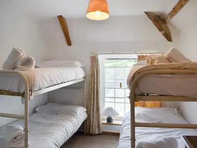 two bunk beds in a room with a window at Mermaid Cottage - Uk47403 in Portmellon