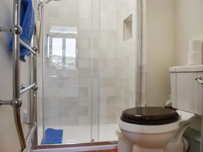 a bathroom with a toilet with a glass shower at Corner Cottage - Uk47402 in Portmellon