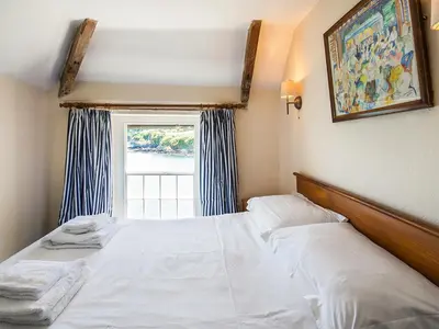 a bedroom with a white bed with a window at Corner Cottage - Uk47402 in Portmellon