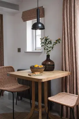 a dining room table with a vase on top of it at Kittiwake apartment - Coastal, luxury, self-catering in Port Isaac