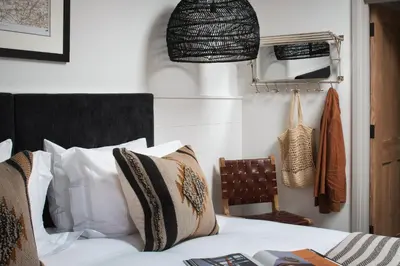 a bedroom with a bed and a pendant light at Kittiwake apartment - Coastal, luxury, self-catering in Port Isaac