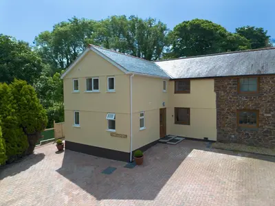 a large white house with a brick at Chy Lowen, Treluswell in Penryn