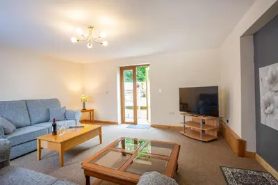 a living room with a blue couch and a tv at Chy Lowen, Treluswell in Penryn