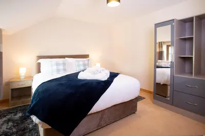 a bedroom with a large bed and a mirror at Chy Lowen, Treluswell in Penryn