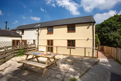 a house with a picnic table in front of it at Chy Lowen, Treluswell in Penryn