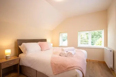 a bedroom with a bed with two towels on it at Chy Lowen, Treluswell in Penryn