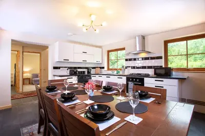 a kitchen with a wooden table with wine glasses at Chy Lowen, Treluswell in Penryn
