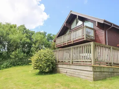 a house with a large deck on the side of it at The Willows in Saint Columb Major