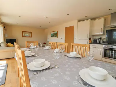 a dining room with a table with plates and wine glasses at The Willows in Saint Columb Major