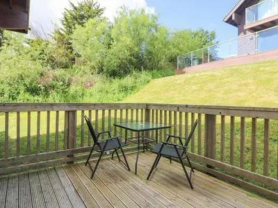 a table and two chairs on a deck at The Willows in Saint Columb Major