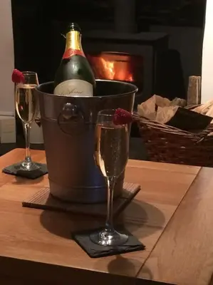a bucket with a bottle of champagne and two glasses at November Cottage St Kew, North Cornwall Cosy Cottage in Bodmin